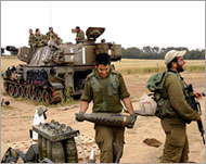 An Israeli soldier carries an artilleryshell to fire on Gaza on Tuesday