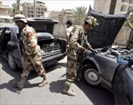 Iraqi soldiers check vehicles at a checkpoint in central Baghdad