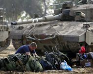 An Israeli soldier prepares his equipment outside the Gaza Strip 
