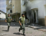 Israeli border policemen run from rockets fired by Hezbollah.