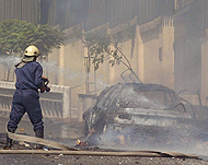 Syrian firefighter hoses down aburnt car near the US embassy