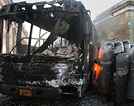 Police inspecting a burnt bus inOaxaca after Sunday's clashes