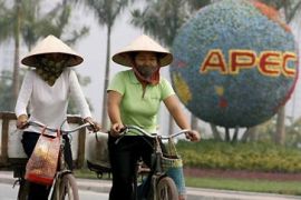 Vietnamese women cycle past a floral decoration outside the venue of Asia-Pacific Economic Cooperation (APEC) in Hanoi Vietnam