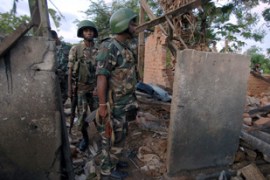 Sri Lankan soldiers look at debris of a house destroyed by a shell attack in the northeastern village of Kallar