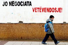 An ethnic Albanian boy passes by a graffito reading: "No negotiation - Self-determination" in Pristina, 25 January 2007.