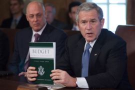 US President George W. Bush holds a copy of the 2008 Fiscal Budget during a meeting with his cabinet as Treasury Secretary Henry M. Paulson (L) looks on 05 February 2007 in the Cabinet Room of the White House in Washington, DC