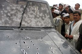 Afghans look at a car, damaged by bullets after an incident involving foreign troops, in Spin Pul village in the eastern province of Ningarhar March 4, 2007