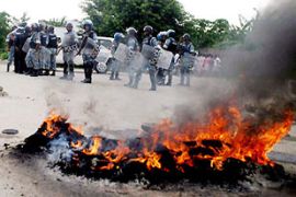 UN peacekeepers stand guard in front of buring tyres set on fire by supporters of East Timor rebel Major Alfredo Reinado