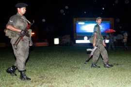 Sri Lankan soldiers patrol near a public television set-up