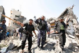 Members of the Hamas Executive Force inspect their destroyed building after an Israeli air strike in Gaza
