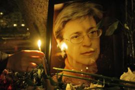 Mourner places a candle next to picture of murdered Russian journalist Anna Politkovskaya