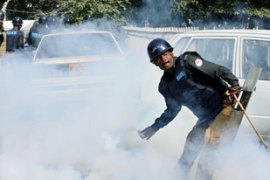 Police officer throws tear gas