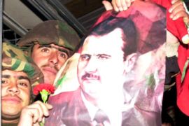 Troops hold Bashir al-Assad posters