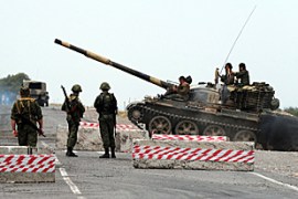 Russian soldiers looks at a tank passing at a checkpoint on the Gori-Tbilisi