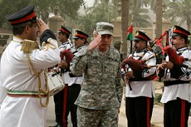 U.S. military commander in Iraq General David Petraeus salutes an Iraqi military band during a farewell ceremony for him in Baghdad