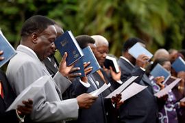 Government ministers of the Zimbabwe''s new inclusive government hold bibles as they are being sworn in