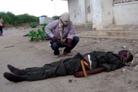 Somali fighters stands over dead body of government soldier