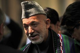 MH03 - Kabul, -, AFGHANISTAN : Afghanistan''s President Hamid Karzai greets visitors at a lunch to mark the anniversary of the 1992 Mujahedin victory at the presidential palace in Kabul on April 28, 2009. The war-torn country on April 28 marks the anniversary of the 1992 Mujahedin victory over the Communist regime in Kabul. AFP PHOTO/Massoud HOSSAINI/POOL