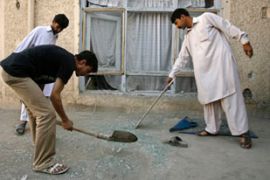 Afghan men clear up after Kabul rocket attack