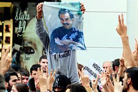 A masked Kurdish man display an image of jailed Kurdish PKK rebel leader Abdullah Ocalan