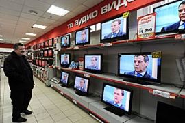 A man watches Russian President Dmitry Medvedev on television sets at an electronics store during his interview on December 24, 2009 in Moscow.