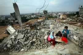 Palestinian play in the rubble of their razed home