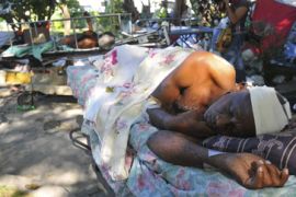 A man injured rests while he waits to be assisted in Port-au-Prince, Haiti