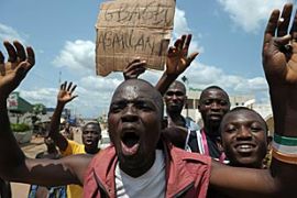 Ivory Coast''s opposition supporters hold a placard reading "Gbagbo the attacker" in the central town of Toumodi
