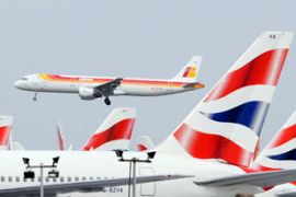 Iberia Airlines passenger jet passing over British Airways aircraft