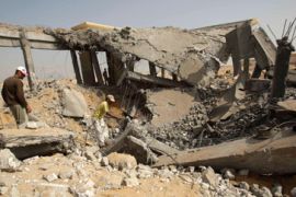 Palestinians survey building hit by an Israeli air strike