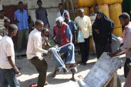Somalian bystanders assist to a man injured in Mogadishu