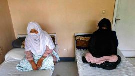 Afghan women sit on beds