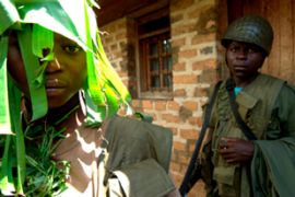 A child soldier from the Mai-Mai militia guards