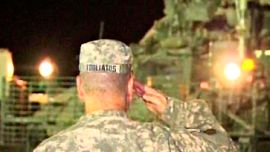 Video frame grab shows Brigadier General Tooliatos saluting as the last U.S. combat troops leave Iraq and cross the border into Kuwait in this video image