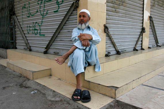 Man sits outside closed Karachi market