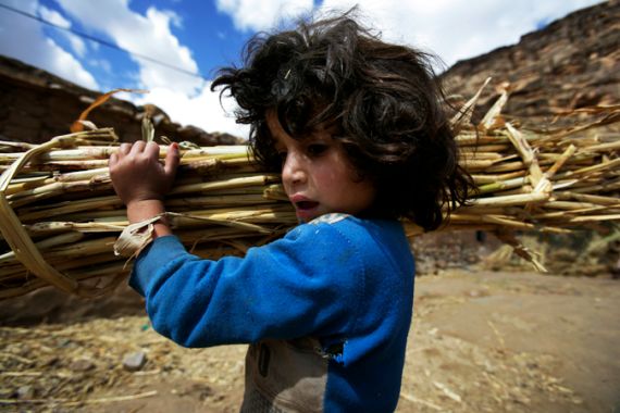 Yemeni child carrying straw