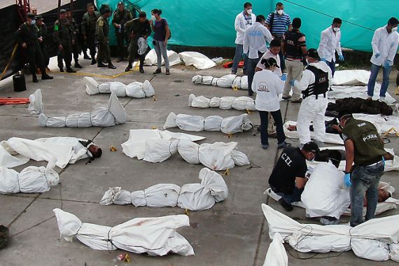 Police inspect the bodies of suspected members of the Revolutionary Armed Forces of Colombia