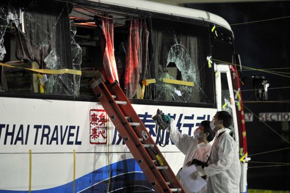 Members of a Hong Kong police forensic team examine the tourist bus involved in the bus hostage crisis