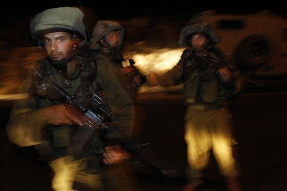 Israeli soldiers guard along a highway near the site of a shooting attack near the West Bank Jewish settlement of Kiryat Arba