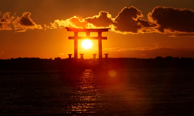 The sun goes down through a torii gate in Japan