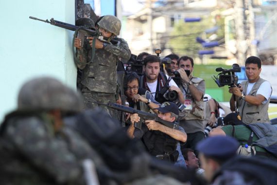 Soldiers, police and journalists take up positions in slum offensive