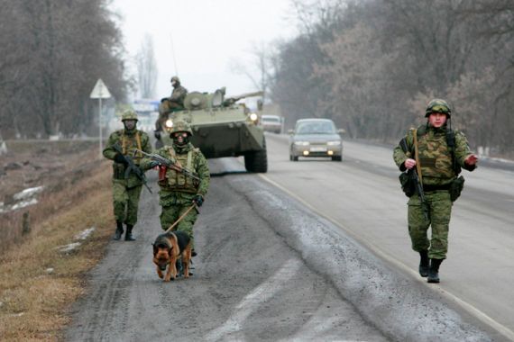 Troops patrol with tank and dog