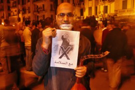 Al Jazeera - picture of protester with a poster of Mubarak