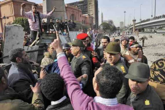 Egyptian army officers stand amid protesters near a barricade as supporters and opponents of President Hosny Mubarak clash in parts of the Tahrir square, Cairo, Egypt, 03 February 2011