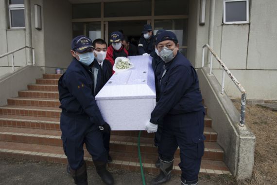 Masked Japanese police carry coffin