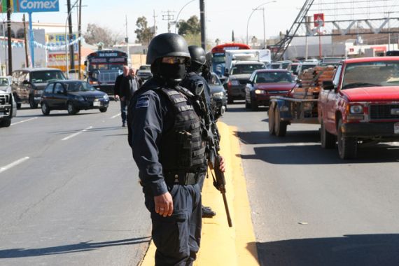 Juarez18:cop on the road with mask (possible opener0 [Chris Arsenault/Al Jazeera]