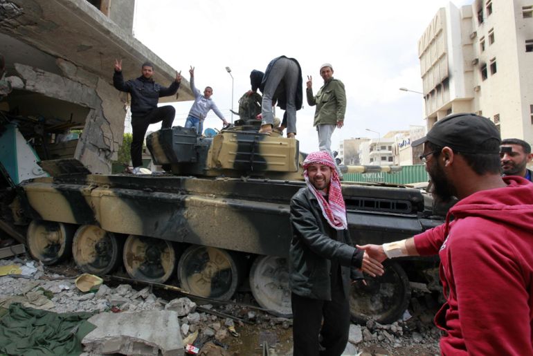 Rebel fighters celebrate next to a captured Gaddafi forces tank at Tripoli street - Misurata