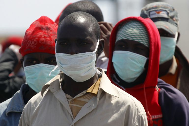 Migrant workers from Africa stand in line at a port in Misrata during an evacuation operation