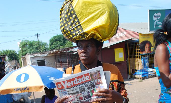 Mozambican woman reading newspaper