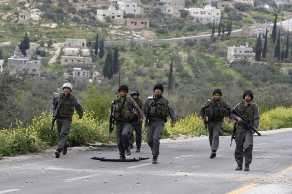 Israeli border policemen run towards Palestinian stone-throwers during clashes outside the West Bank Palestinian village of Awarta, near Nablus March 22, 2011. Israeli troops have been operating in the area since the fatal stabbings of a Jewish couple and three of their children in a nearby West Bank settlement on March 12, in what Israel says was an attack by Palestinian militants. REUTERS/Abed Omar Qusini (WEST BANK - Tags: POLITICS CIVIL UNREST)